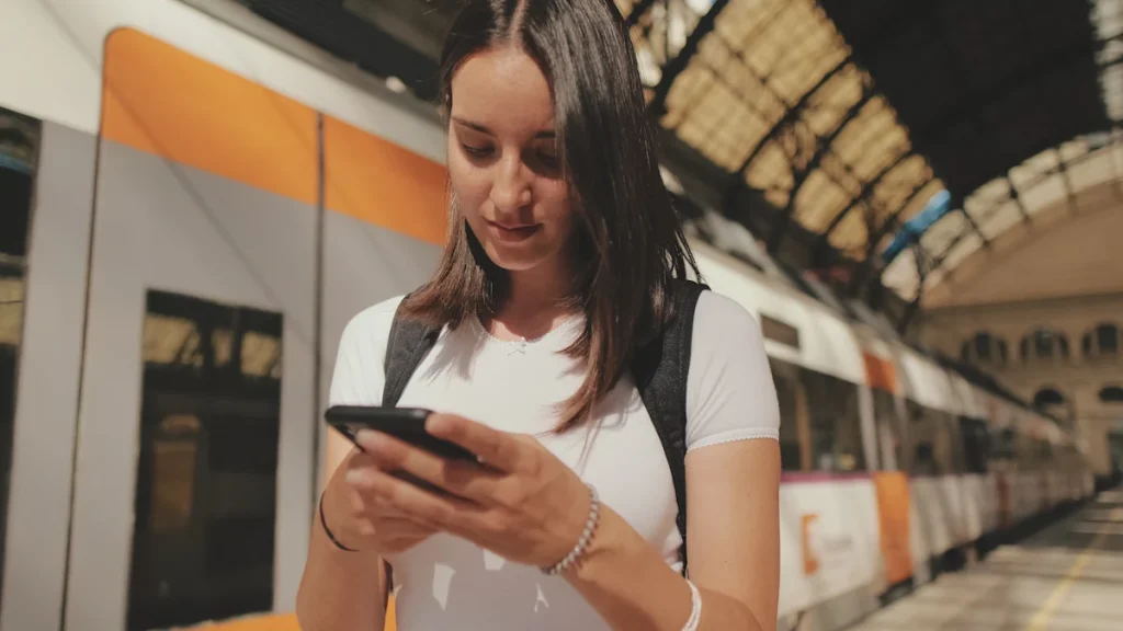 Une femme qui consulte une appli pour les transports en commun à l'étranger