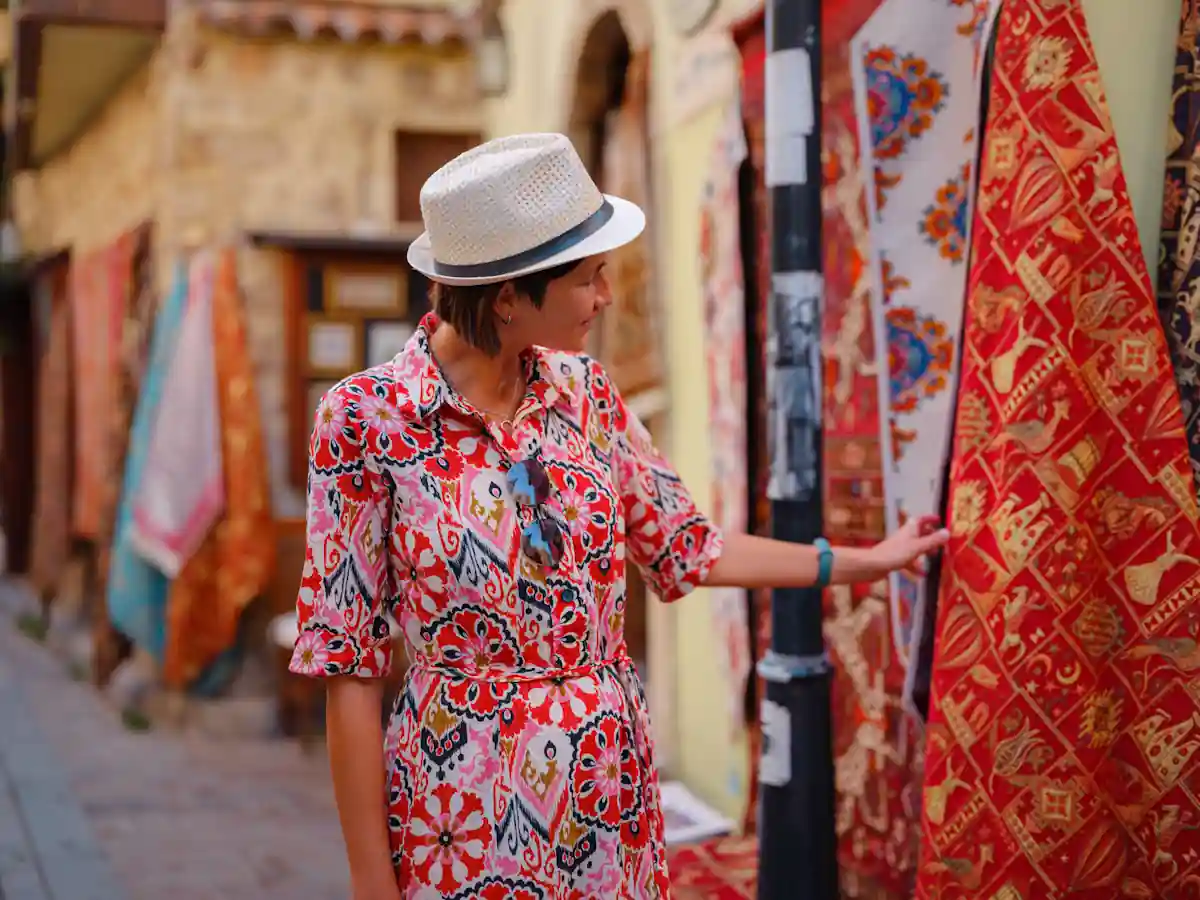 Une femme qui regarde un djellaba brodé dans un marché 