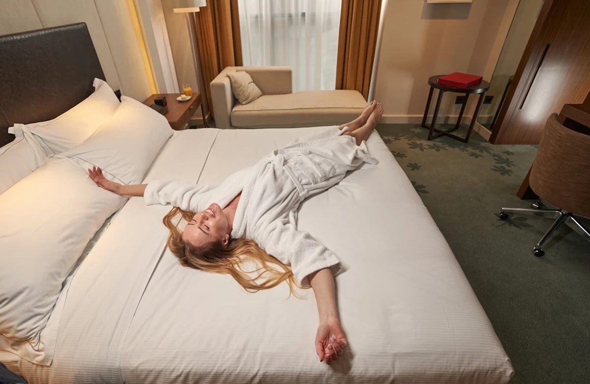 Une femme allongée sur un lit de chambre d'h^tel