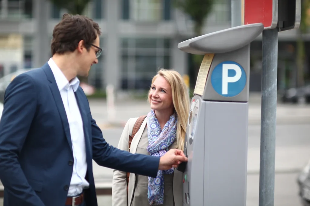 Un homme qui paye un horodateur de parking